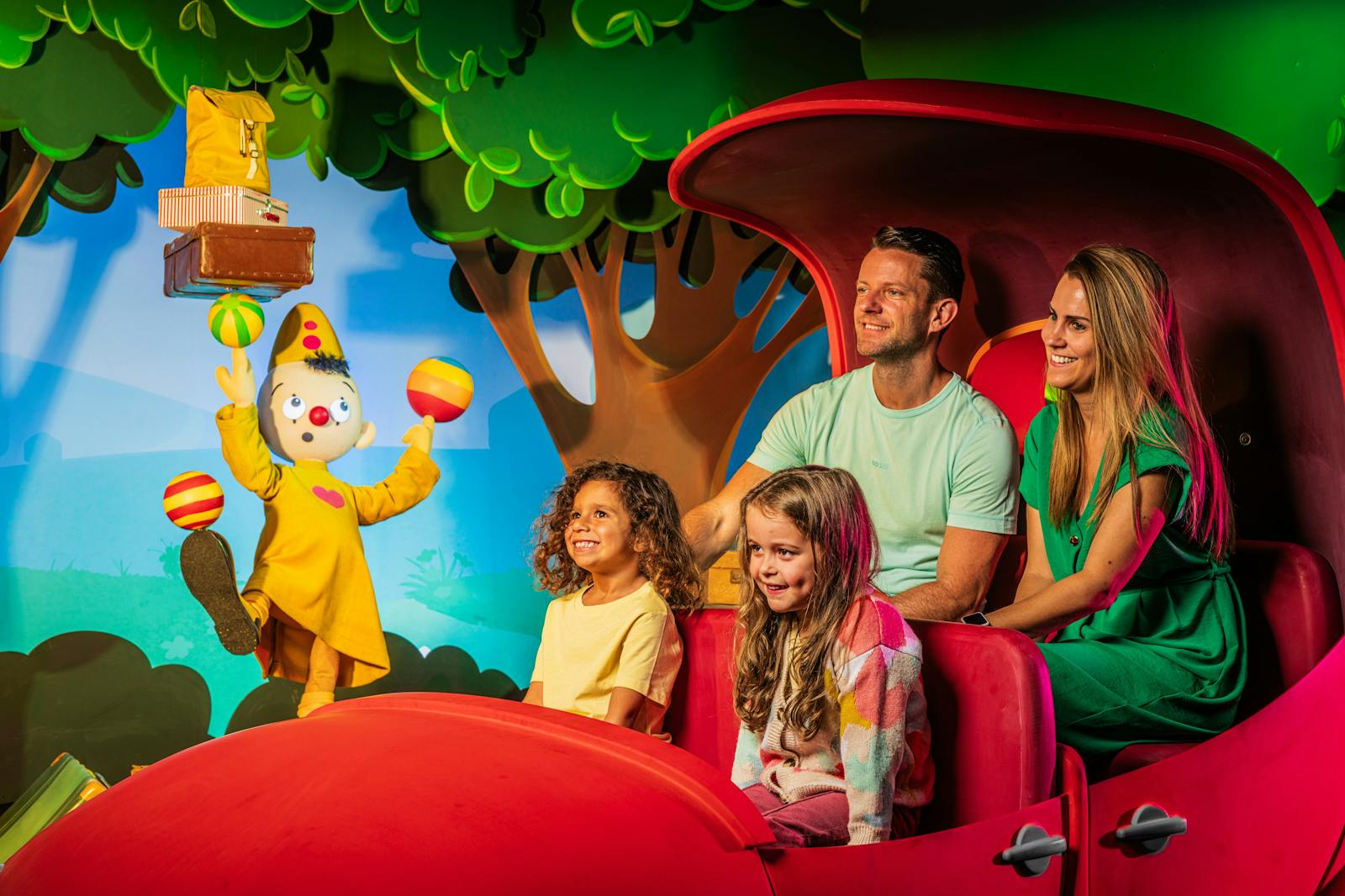 Uśmiechnięta rodzina na atrakcji Plopsaland Belgium z klaunem